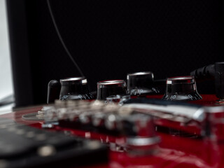 Fototapeta na wymiar Red electric guitar. Electric guitar settings. Red guitar. Close-up.