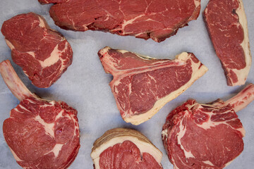 Overhead Shot Of Different Cuts Of Beef Steak On Background In Butcher's Shop Display