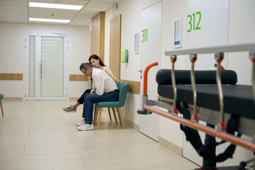 Fototapeta na wymiar Woman comforting a man in the corridor of a medical center