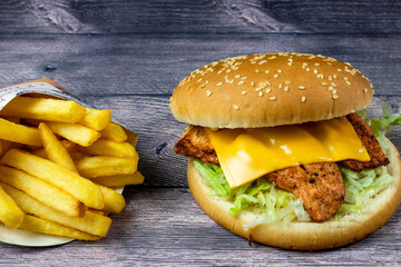 panini fast-food con pane sesamo e patatine su sfondo grigio