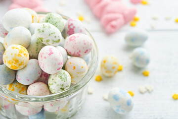 Fototapeta premium Sweet Easter concept. Sweet Easter kids holiday assortment marshmallows rabbit, chocolates easter eggs, candies, bunny, snacks on white wooden background. Flat lay Easter decoration idea. Mock up.