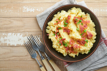Mashed potatoes. Bacon mashed potatoes with green onion, pepper and cheddar cheese in bowl on old wooden backgrounds. Delicious creamy mashed potatoes. Top view.