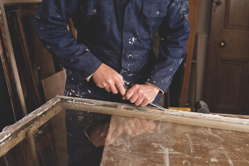 Restoration of old sash windows -  wooden frames are scraped from old patty and paint.