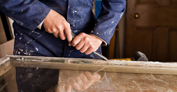 Restoration of old sash windows -  wooden frames are scraped from old patty and paint.