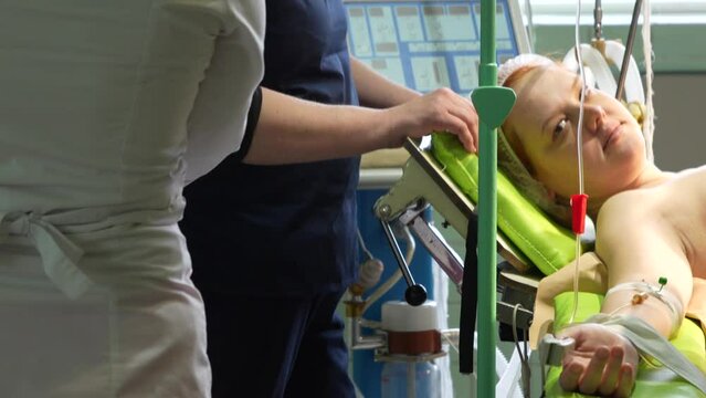 Young girl on the operating table. Preparation for the operation, connecting a dropper intravenously. The process of a caesarean section. High quality 4k footage