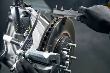 Close up photo of male measuring brake drum wear
