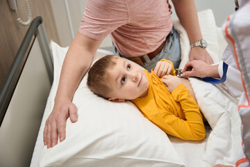Obraz premium Happy cheerful child during the examining health with stethoscope in hospital
