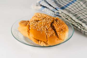 bread sprinkled with sesame seeds is served on a small plate with a napkin isolated on a white background