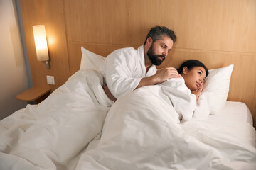 Fototapeta premium Guy comforting his sad female companion in hotel room