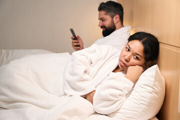 Obraz na płótnie Canvas Depressed female and male with smartphone in hotel room