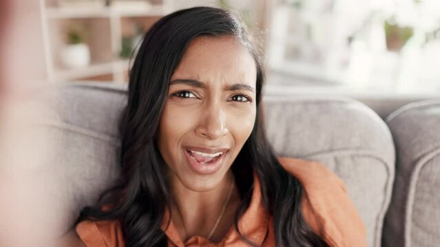 Annoyed woman, phone call and video influencer on living room sofa talking about concerns, vlog or social media at home. Portrait of frustrated female POV on smartphone complaining in communication