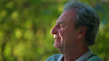 A contemplative senior man enjoying nature. Pensive mature person in 70s. Meditative profile face close up. happiness concept