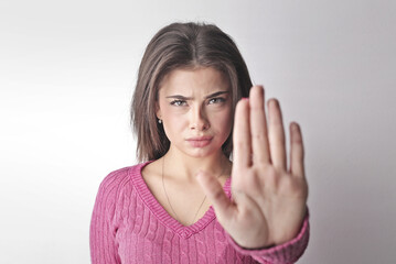 young woman with right hand raised in refusal refuses