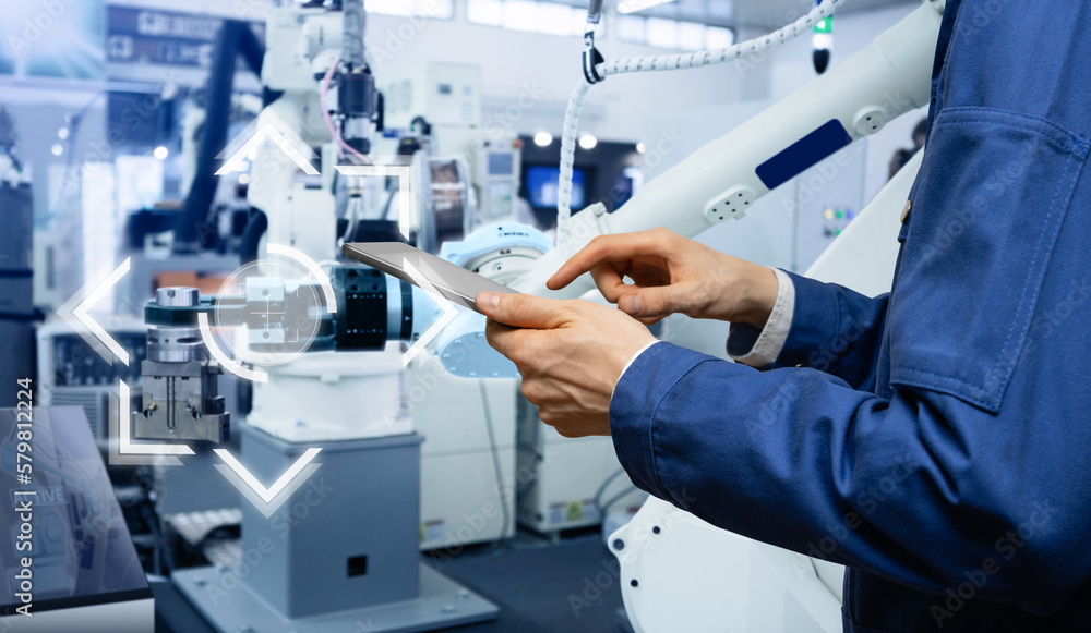 Leinwandbilder engineer uses a digital tablet to control robots in a smart factory. smart industry 4.0 concept