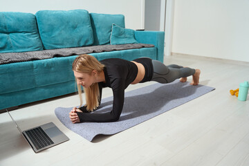 Concentrated fit woman doing isometric core strength exercise on yoga mat