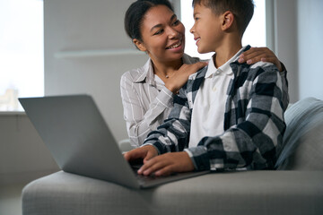 Caring mother helps her son in online learning