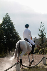 Homem a andar de cavalo com paisagem por trás