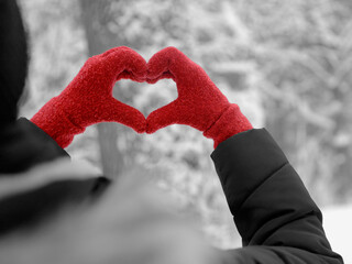 I Love  - A woman is holding her gloved hands in the shape of a heart - Black and white photo where only the gloves are red