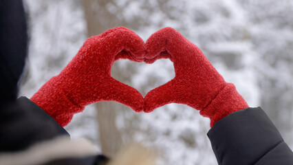 I Love  - A woman is holding her gloved hands in the shape of a heart
