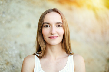 Naklejka premium Portrait of a happy smiling woman standing and looking at the camera in a summer day.