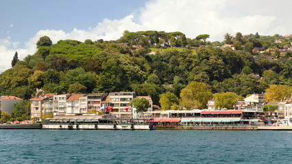 Fototapeta na wymiar View from the sea of the green mountains of the Europian side of Bosphorus strait, with traditional houses and dense trees in a summer day, Istanbul, Turkey