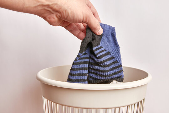 Old socks are thrown into the trash. Disposal and recycling of worn clothes.