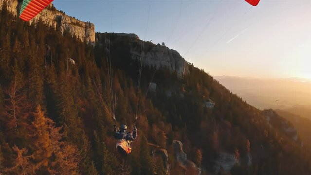 Freedom paragliding flight over rocky forest nature at peaceful sunrise in autumn mountains, Adrenaline Adventure Sport
