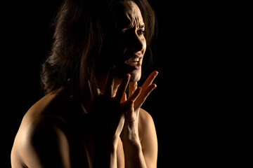 Obraz premium Silhouette of young unhappy crying woman on black background