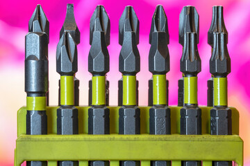 Set of grey steel screwdriver bits with Robertson, Phillips, spline and hex bits in a green plastic holder, nobody - Powered by Adobe