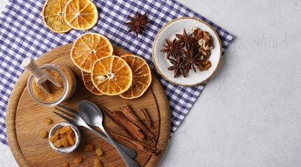 Star Anise, cinnamon sticks, cloves and orange slices for Christmas baking, on wooden board, copy space