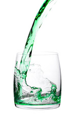 Green apple drink is poured into a transparent glass