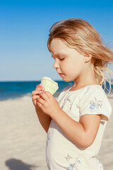 happy child on the beach near the swimming pool outdoors eating ice cream in summer park