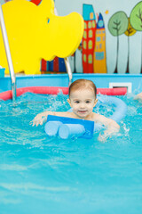 Fototapeta na wymiar Little boy 2 years old are in the pool. Swimming lessons for young children.