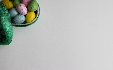 A green Easter egg filled with chocolate-filled eggs in colorful paper on