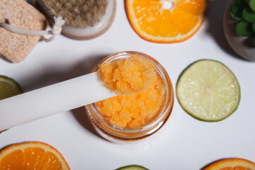 A piece of natural orange scrub on a spatula close-up. Home body care. Spa procedure