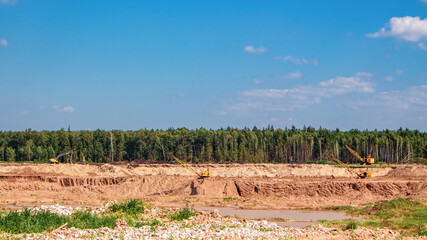 Industrial quarry. Sand mining. Excavators against the backdrop of nature