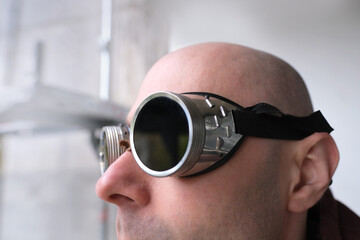 close up part male face, eyes of young pensive man 30 years old in black glasses, steampunk style,...