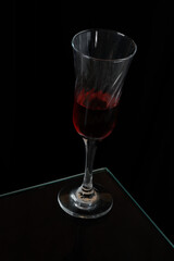 glass goblet with red drink isolated on black background