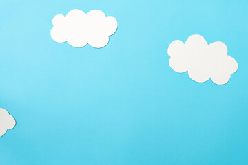 White paper clouds and sky concept on a blue paper, flat lay, top view