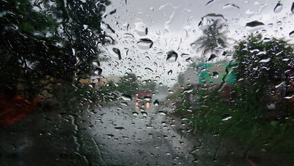 Raindrops on the windshield of car in the rainy season. Selective focus used.