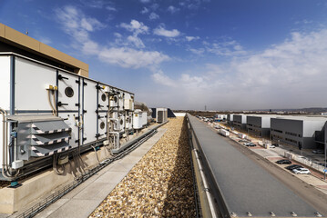 Obraz premium Rooftop of a factory building with air conditioning and air cleaning equipment and gravel-covered floors