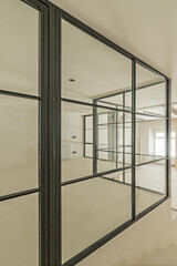 Metal and glass enclosure with a few angles of a loft with polished white cement walls and floors