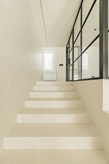 White polished concrete stairs with access to a closed room with metal and glass glazing