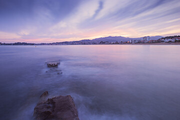 Long exposure image of a half-ruined stone pier hit by the rising tide on a Galician beach