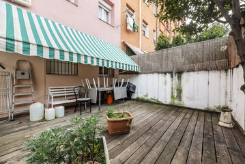 Terrace patio of a house on the ground floor with some plants and unvarnished acacia wood floors