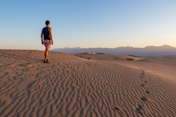 Touristic man enjoying the sunrise with scenic view on Mesquite Flat Sand Dunes, Death Valley...
