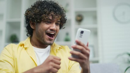 Amazed handsome man receiving sms message offer opportunity arabian happy man reading good news in smartphone Excited overjoyed indian male winner celebrating success mobile phone victory notification