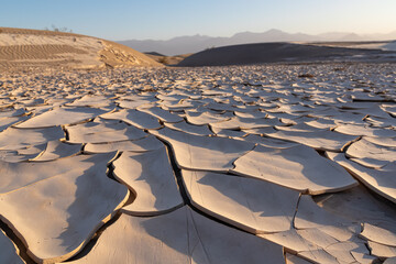 Scenic view of dry cracked clay crust at Mesquite Flat Sand Dunes in Death Valley National Park, California, USA. Looking at pattern Mojave desert in summer with Amargosa Mountain Range in the back