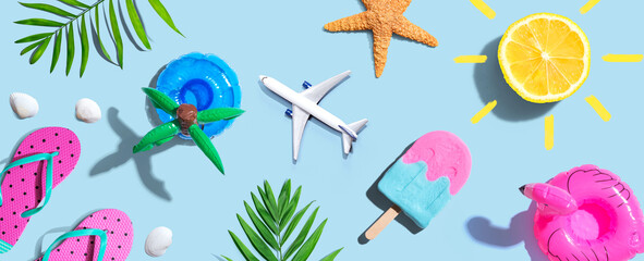 Summer concept with a airplane, a popsicle, flip flops and lemon sunshine - flat lay