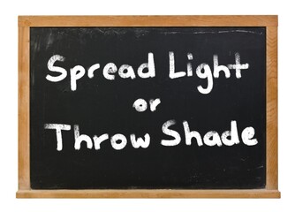 Obraz premium Spread light or throw shade written in white chalk on a black chalkboard isolated on white